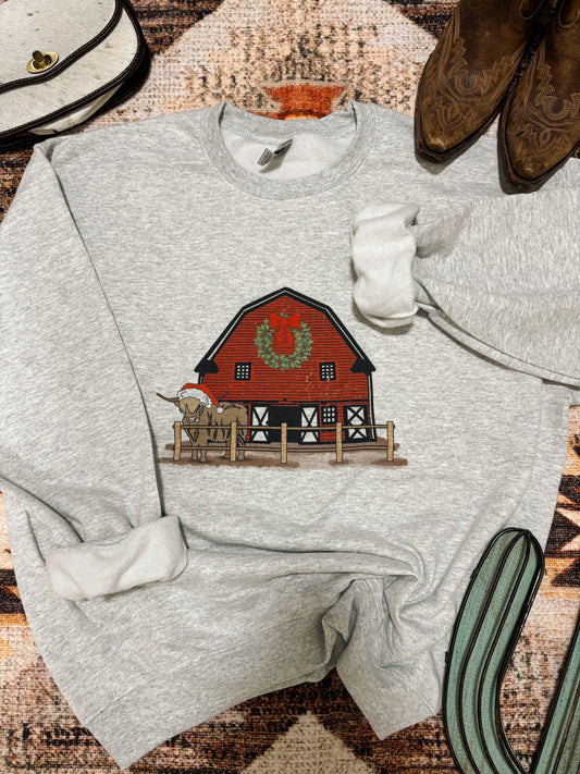 Red Barn Christmas Crewneck laid flat with boots and western accessories