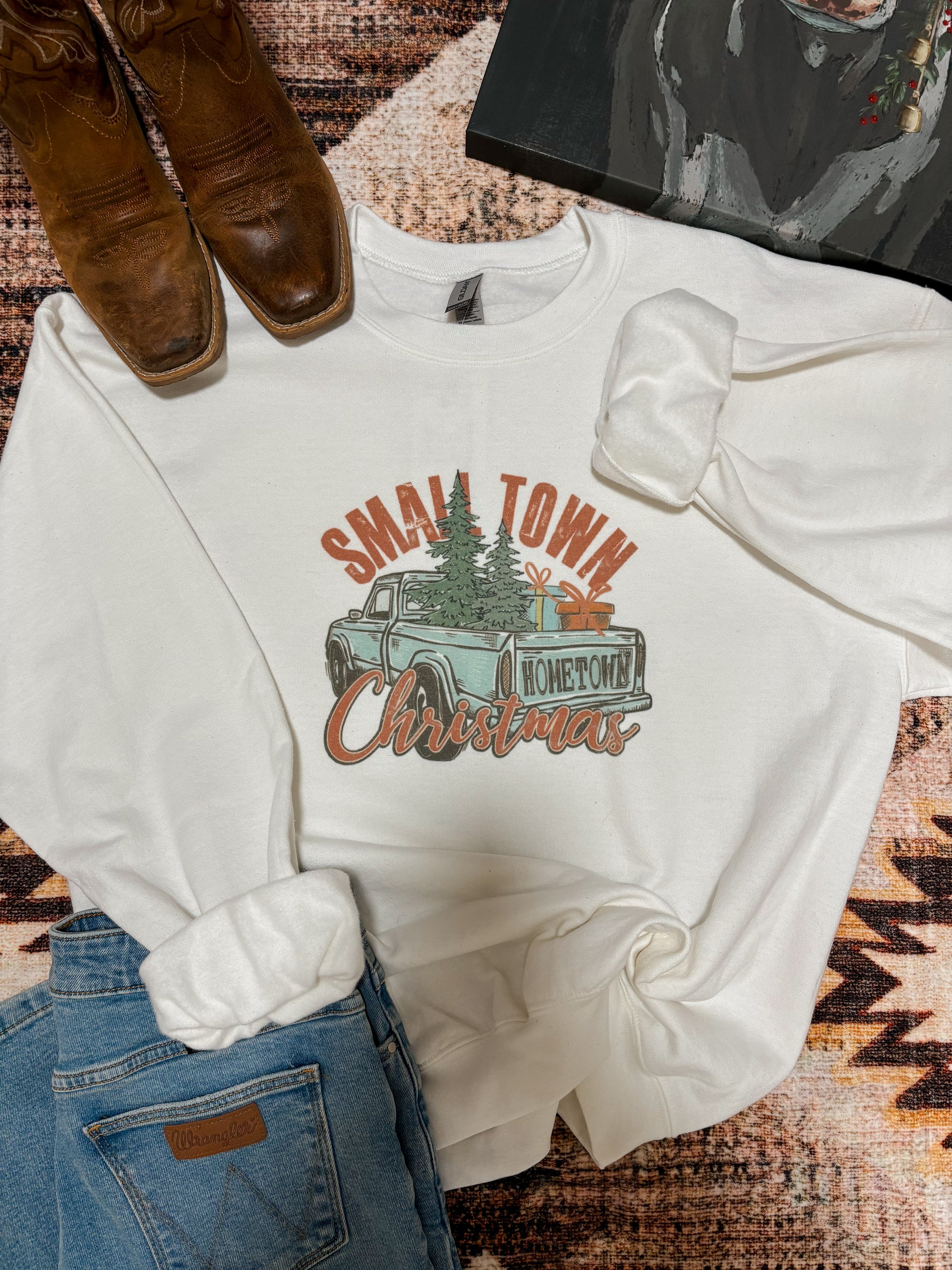 Full view of the Small Town Christmas sweatshirt showing holiday graphic with truck and tree.