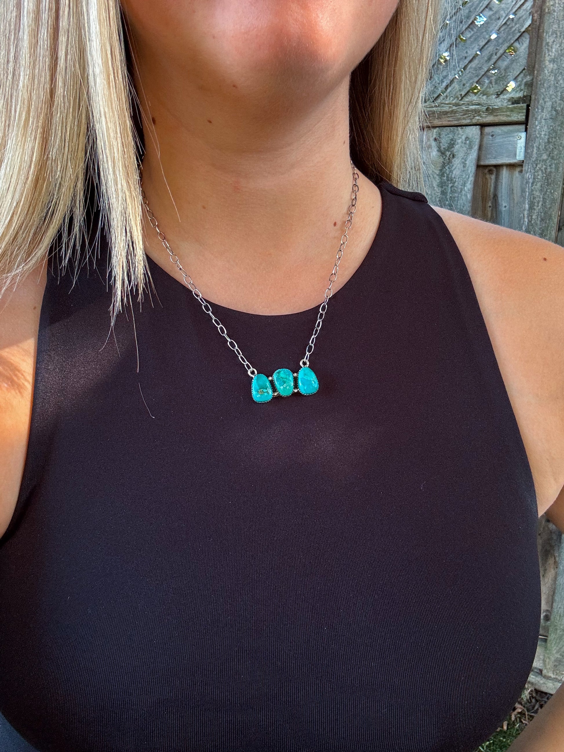 Close up of the Turquoise Wildstone Necklace featuring three stacked turquoise stones on a silver chain.