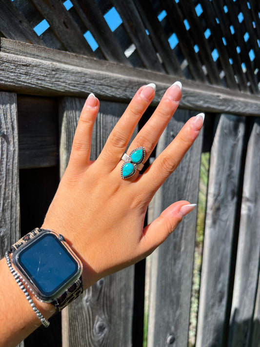 Close up of Hides & Kinds Twin Trails Ring featuring two pear shaped turquoise stones set in silver