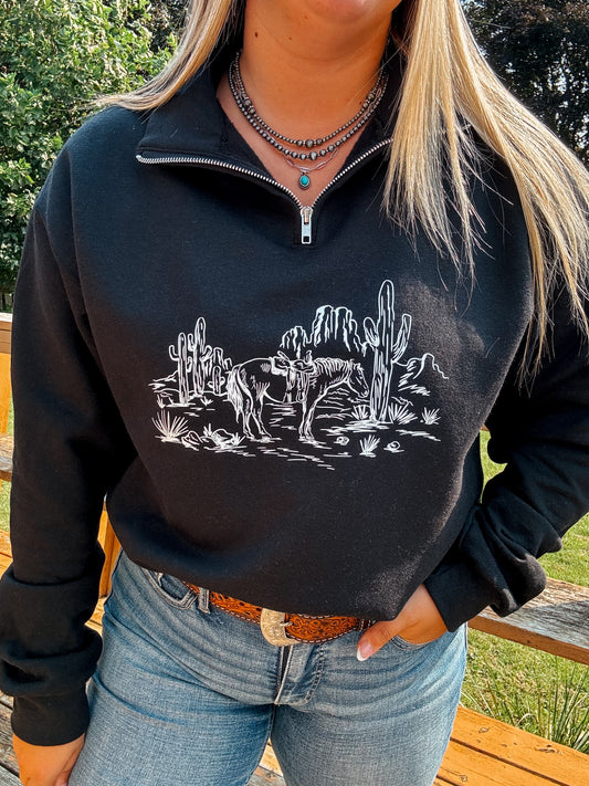 Close up of the black Wild Horse Quarter Zip with western desert horse graphic, styled with turquoise necklace and denim.