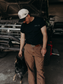 Model wearing the Hides & Kinds Big Buck Tee with a cattle dog, showcasing the men's country lifestyle graphic tee.