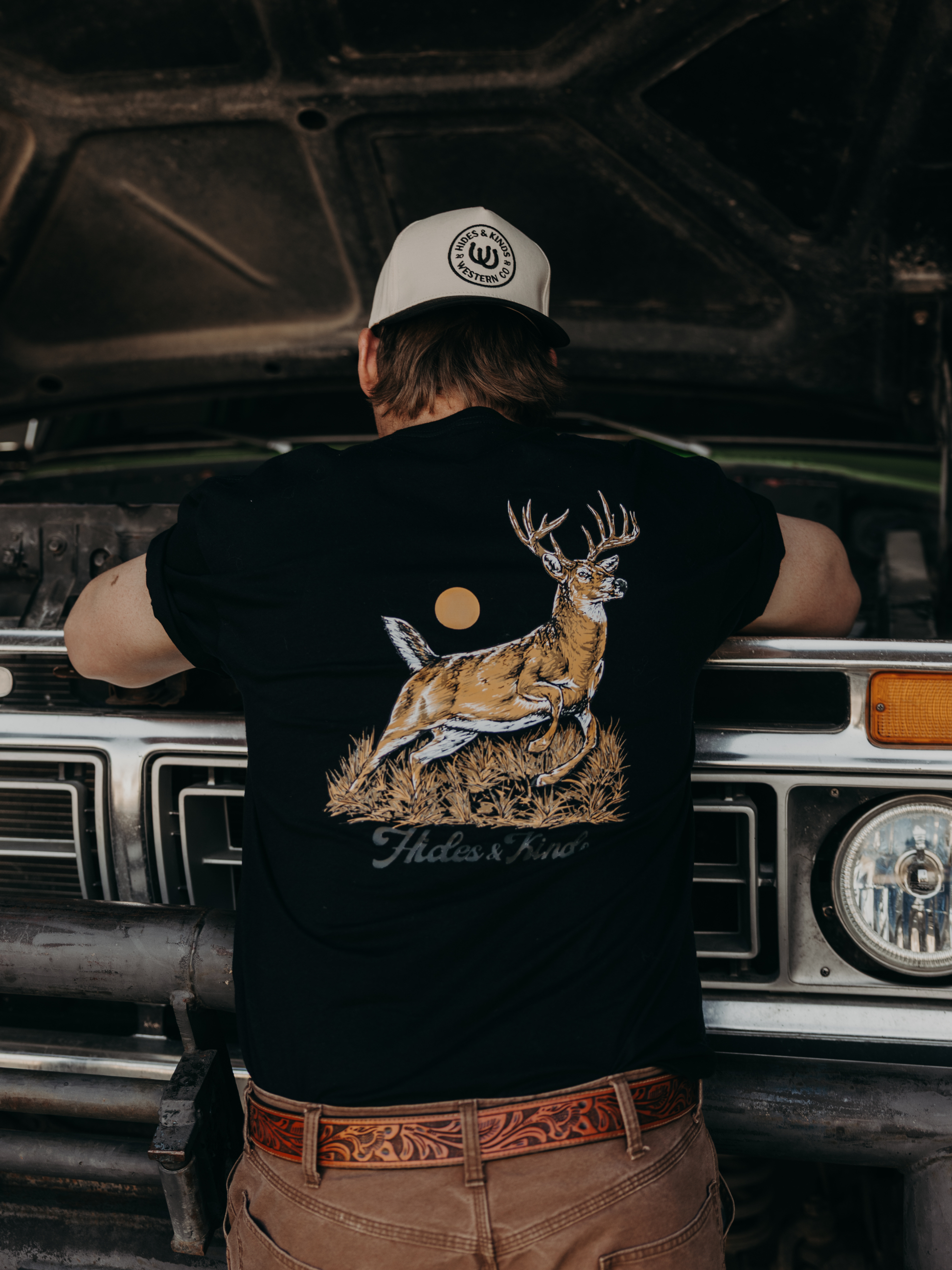 Model wearing the Hides & Kinds Big Buck Tee featuring the back graphic design and deer artwork.