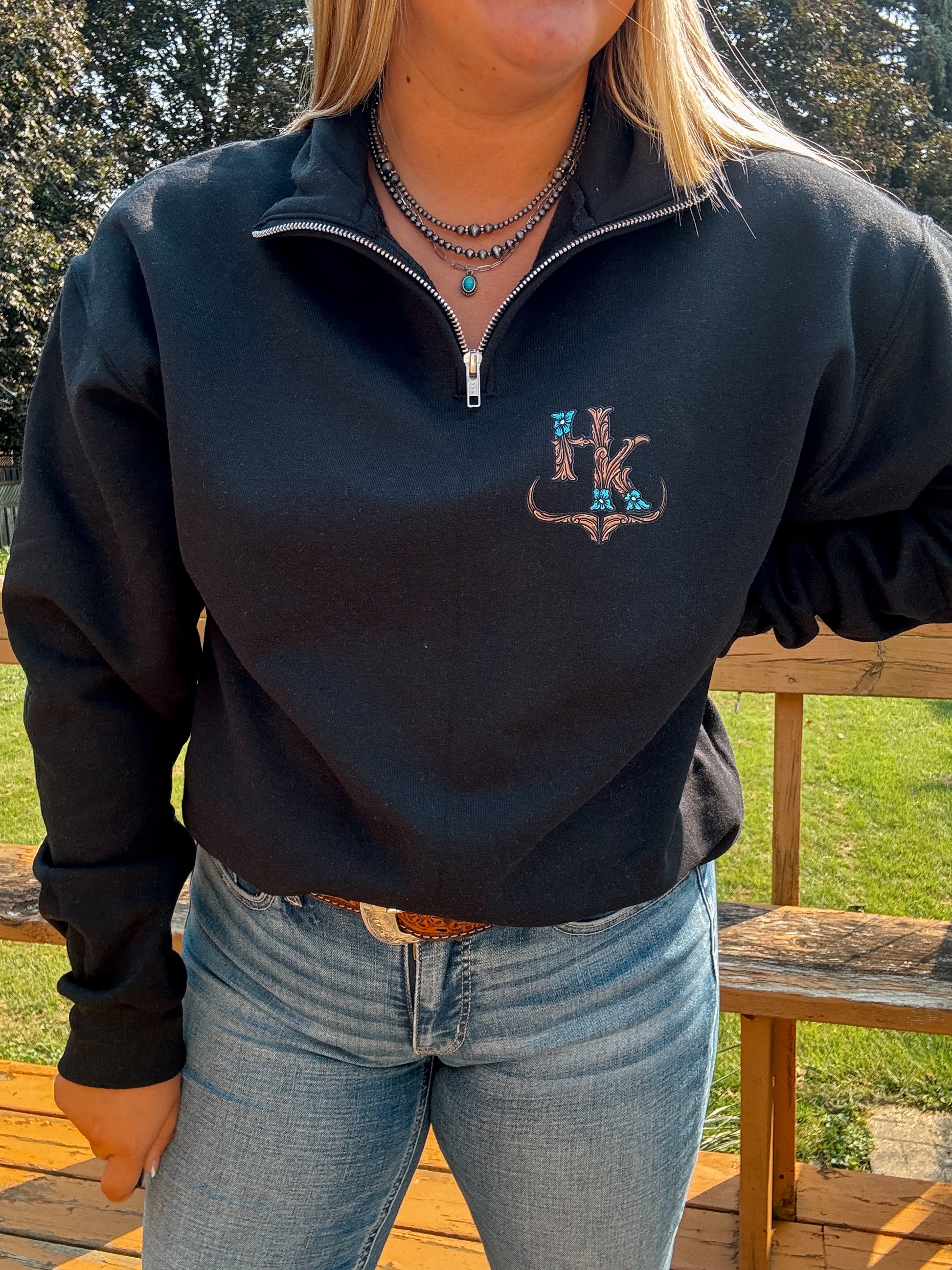 Western quarter zip in black with HK tooled logo detail – casual fit shown styled with turquoise jewelry.