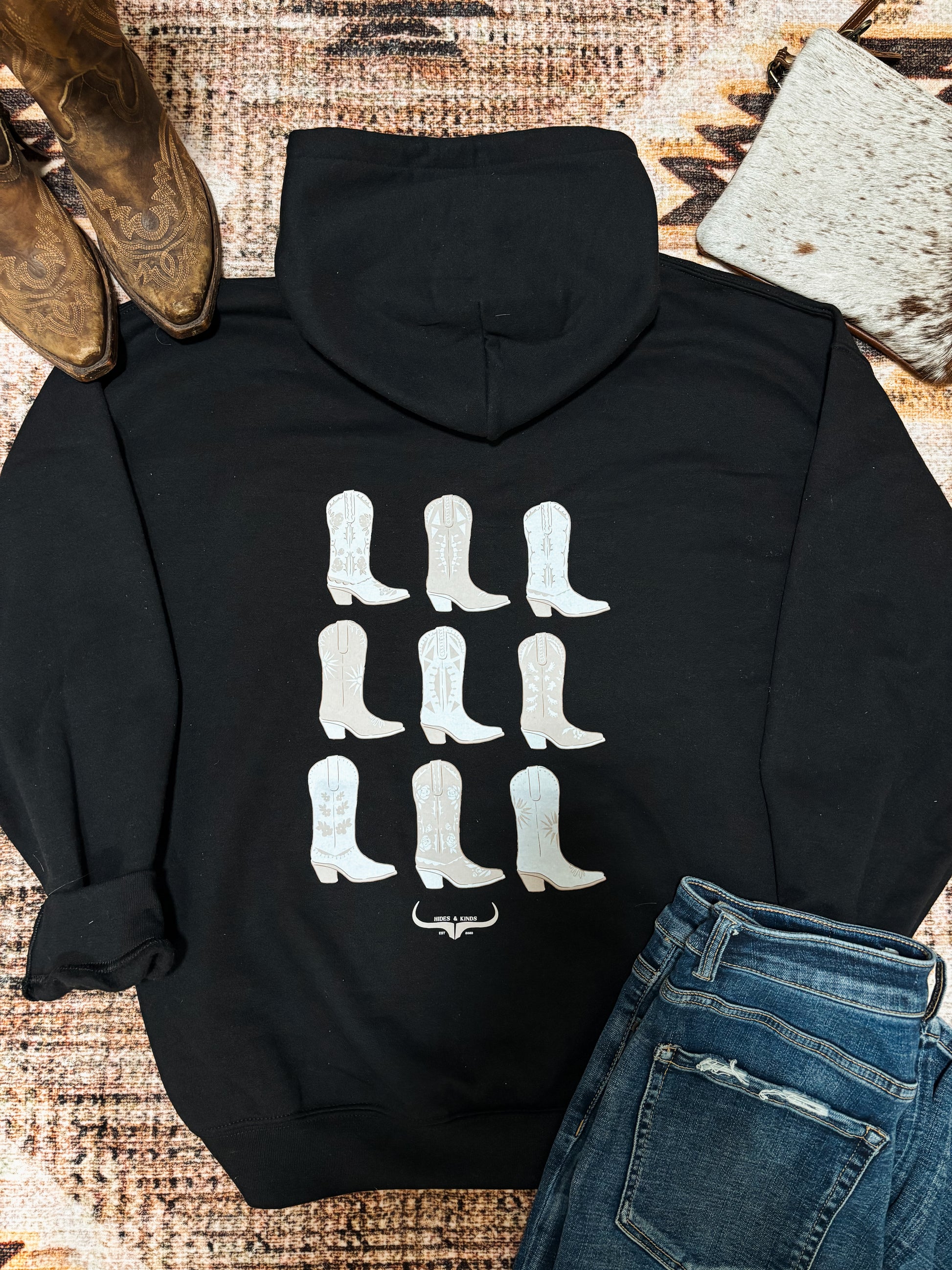 Black Hides and Kinds hoodie featuring nine white cowboy boots on the back