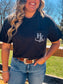 Woman wearing black pocket tee with white H&K logo on the chest, close up