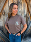 Detailed view of the espresso brown pocket tee with HK logo, styled casually with jeans and a western belt.