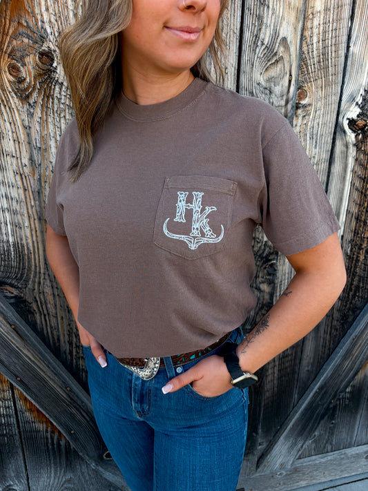 Close up of the HK Branded Pocket Tee in espresso brown, featuring a white graphic logo on the front chest pocket.
