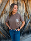 Full outfit shot of a woman wearing the espresso brown branded pocket tee, styled with denim and western accessories.