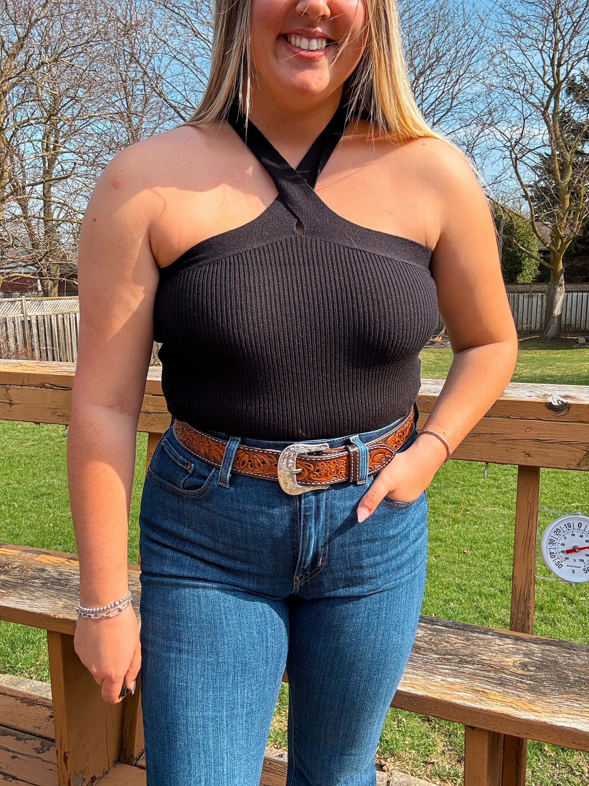Model wearing the Callie Cross Neck Crop Top in black with high-waisted jeans