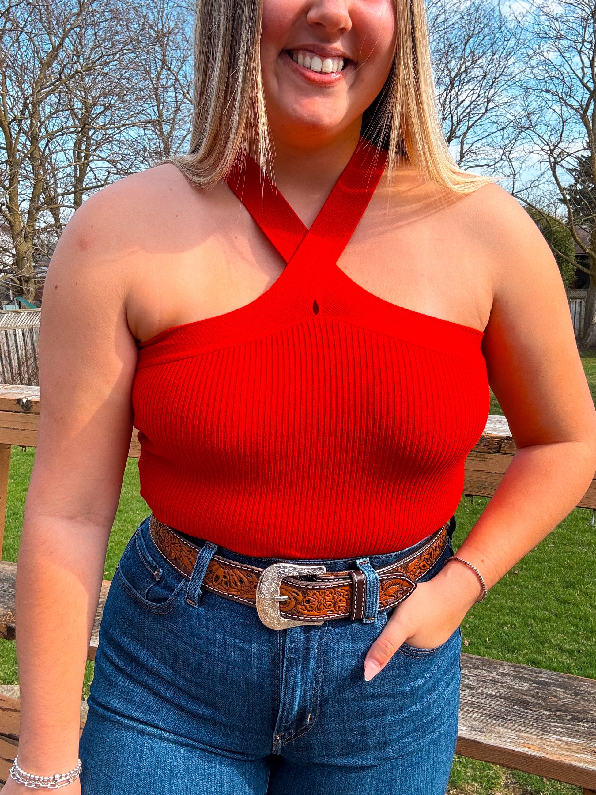 Model wearing Callie Cross Neck Crop Top in red with tooled western belt
