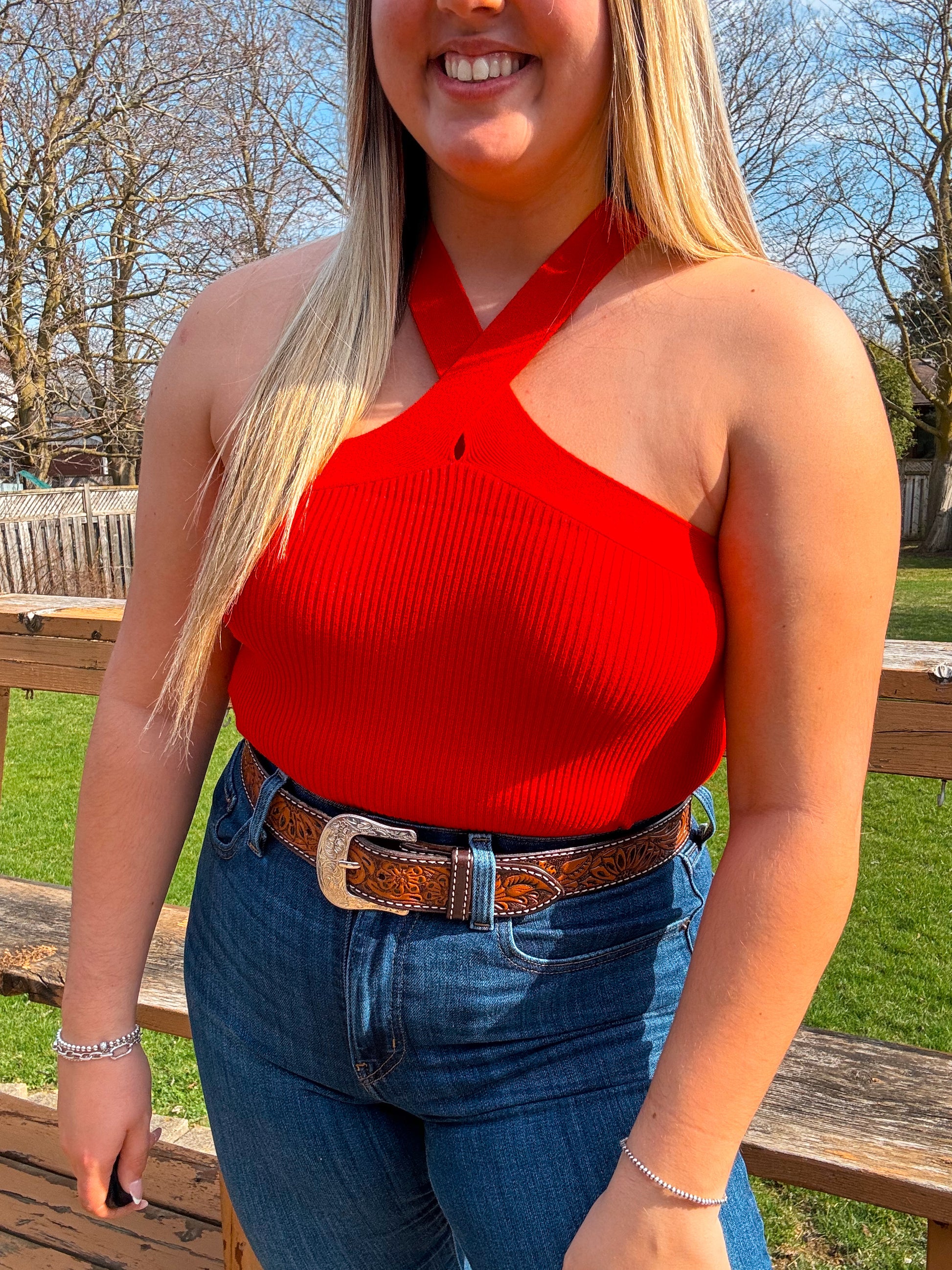 Red cross halter crop top with ribbed knit fabric styled with denim jeans