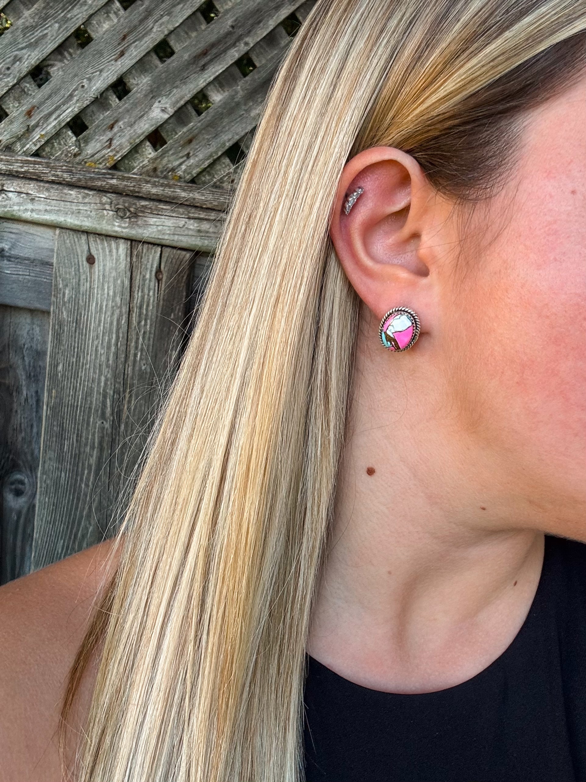 Close up of the Candy Quartz Studs featuring pink and green stones with silver rope detailing, worn on the ear.