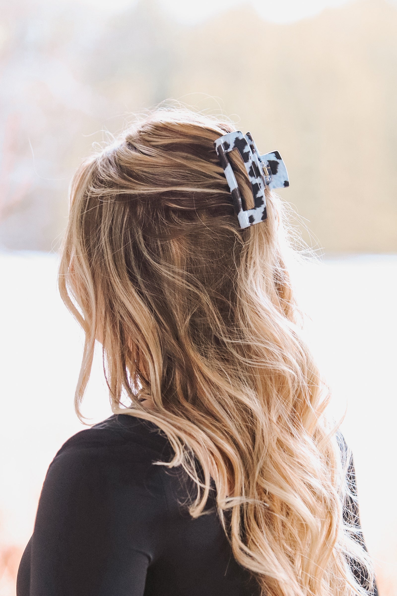 Back view of model wearing cow print hair clip from Hides & Kinds