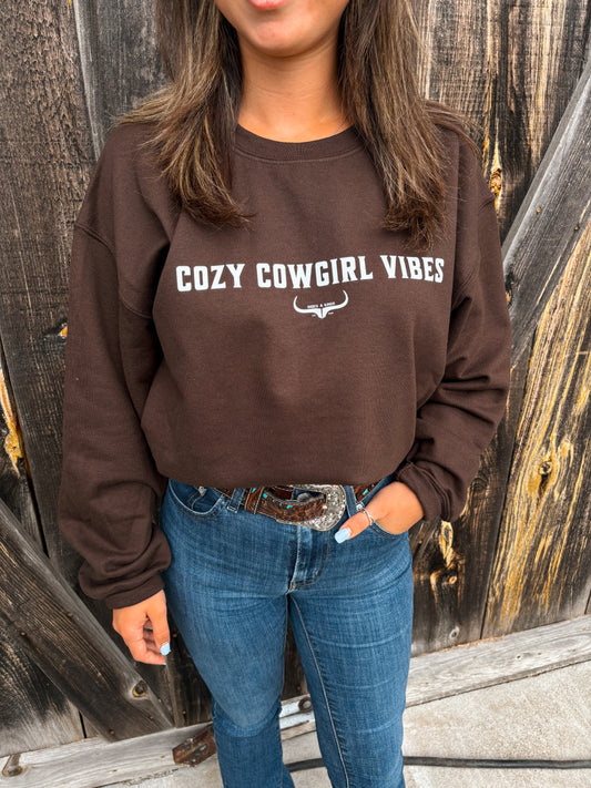 Close up of model wearing the Cozy Cowgirl Vibes Crewneck in chocolate brown from Hides & Kinds