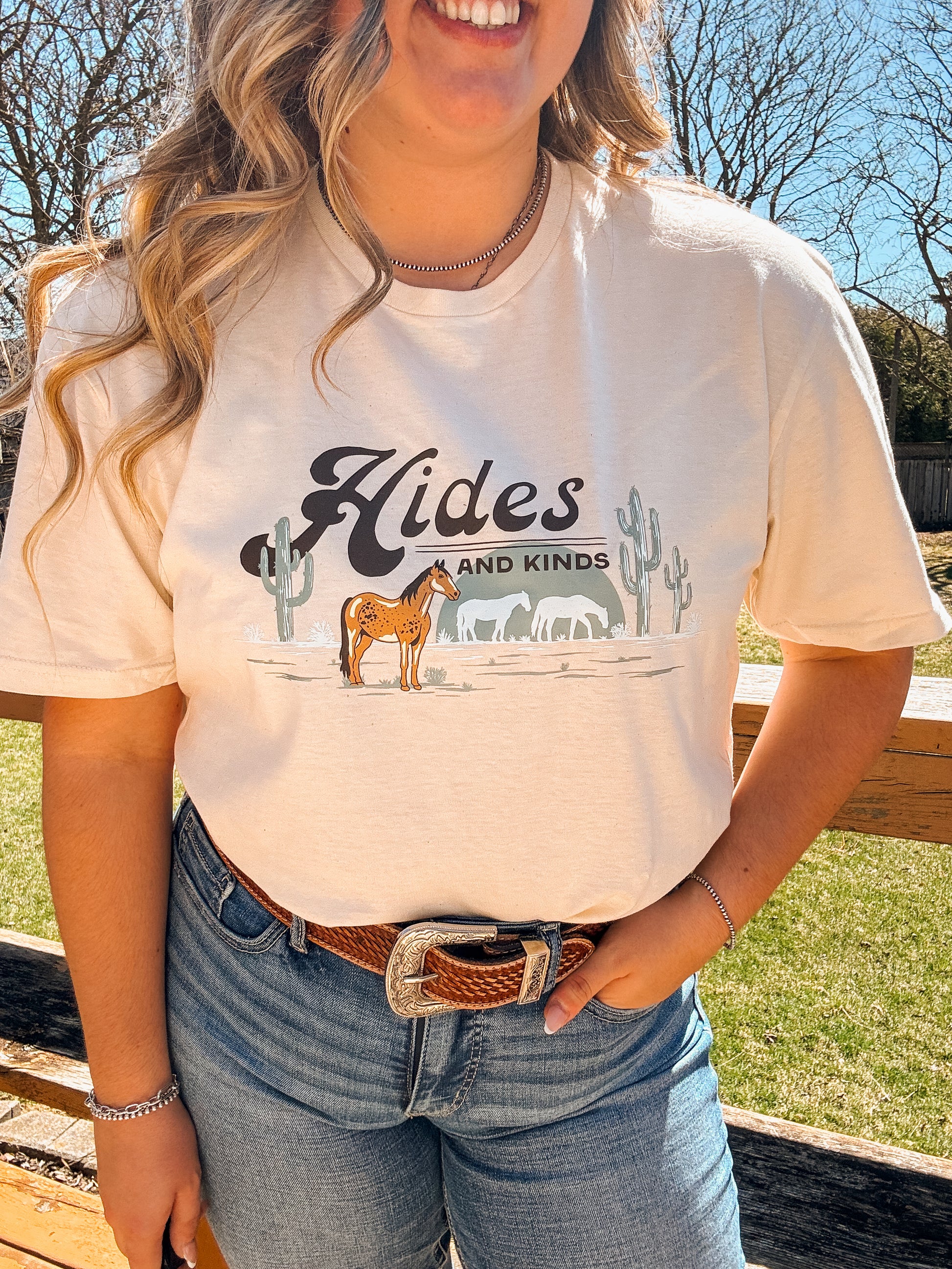 Woman wearing the Desert Horse Tee in natural, showcasing the western horse and cactus graphic up close
