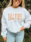 Close up of Fall Vibes graphic crewneck with maple leaf detail, worn tucked into jeans.