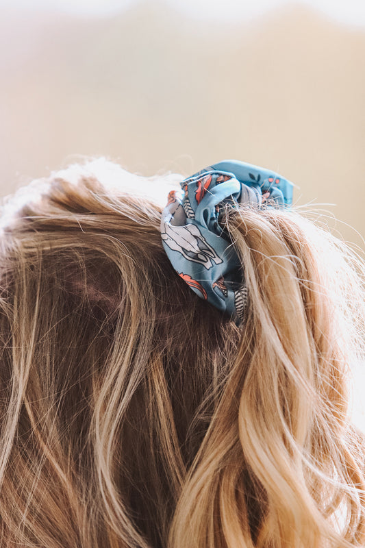 Woman wearing Floral Longhorn Scrunchie in side ponytail, western style hair accessory