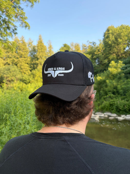 Back view of Hides & Kinds black meshback trucker hat with white embroidered longhorn logo