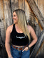 Woman wearing a black Hides & Kinds cropped racerback tank with white western longhorn logo styled with denim jeans and a western belt.