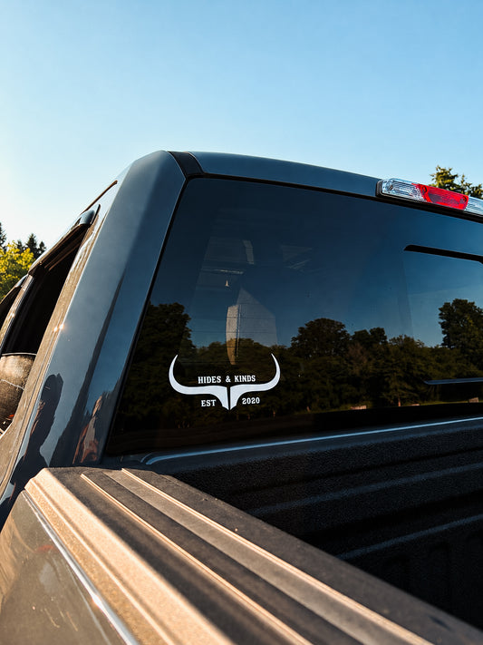 White Hides & Kinds Original Logo Decal featuring the signature longhorn design applied to the rear window of a black pickup truck