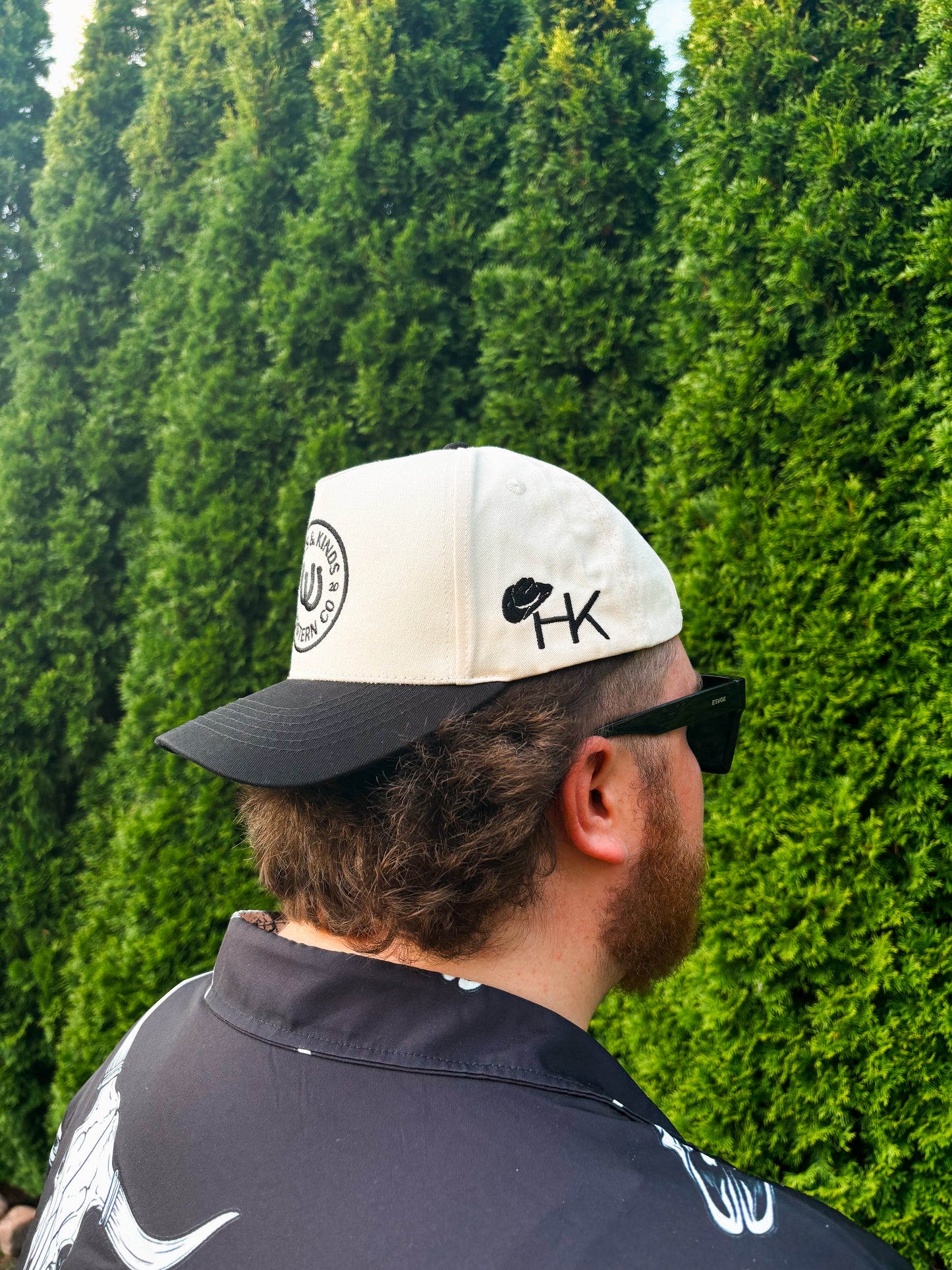  Side profile of man in The Outrider Hat featuring cowboy hat + HK logo.