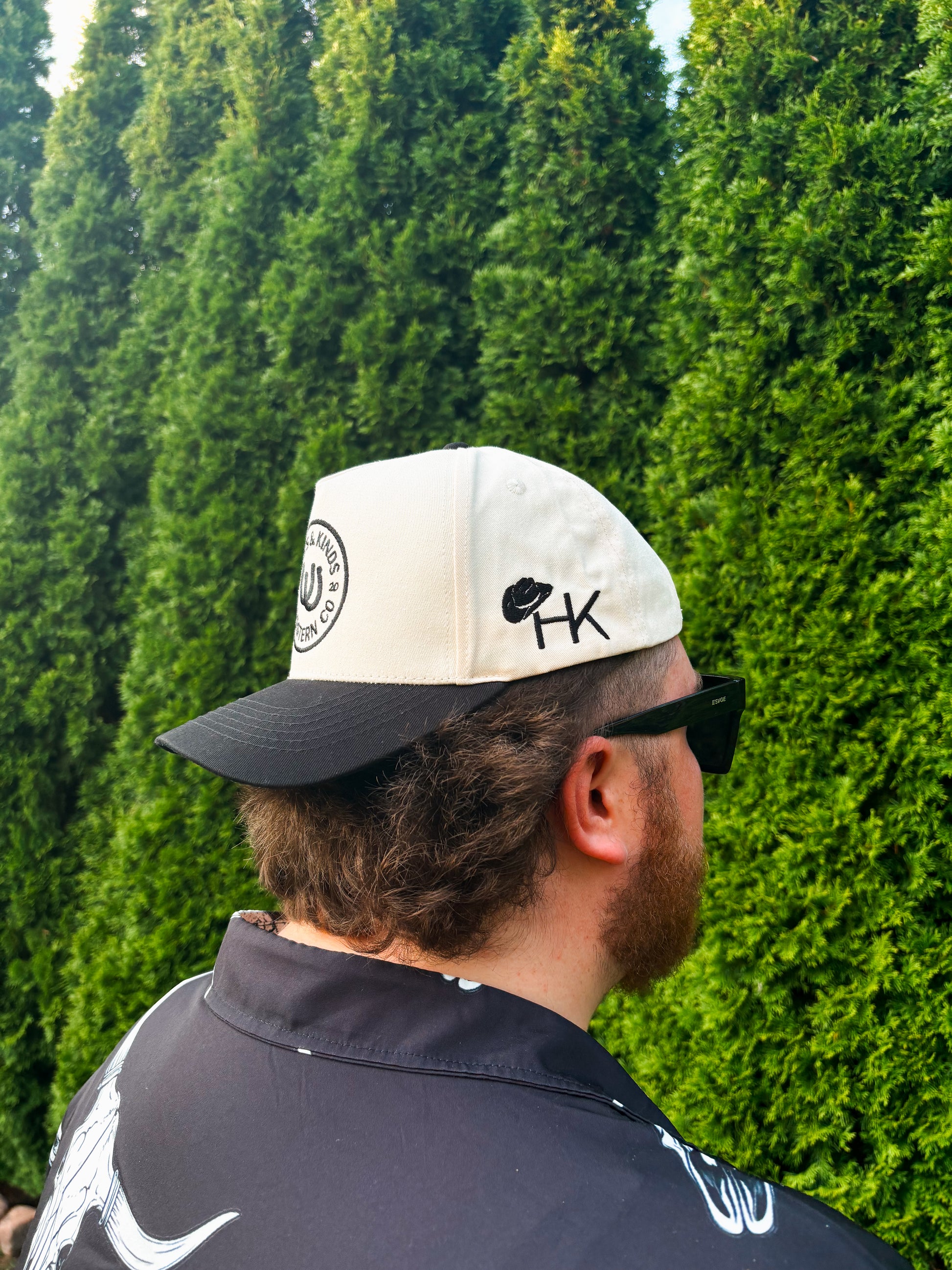  Side profile of man in The Outrider Hat featuring cowboy hat + HK logo.
