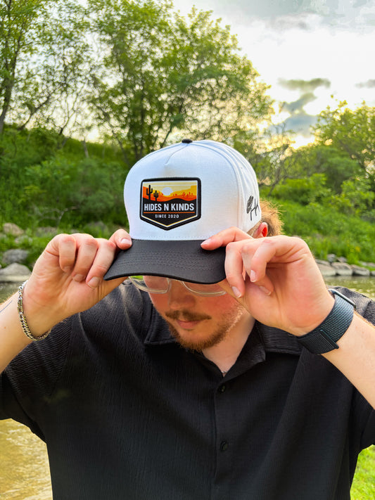 Hides & Kinds Southwest Snapback featuring a white crown, black brim and embroidered desert patch
