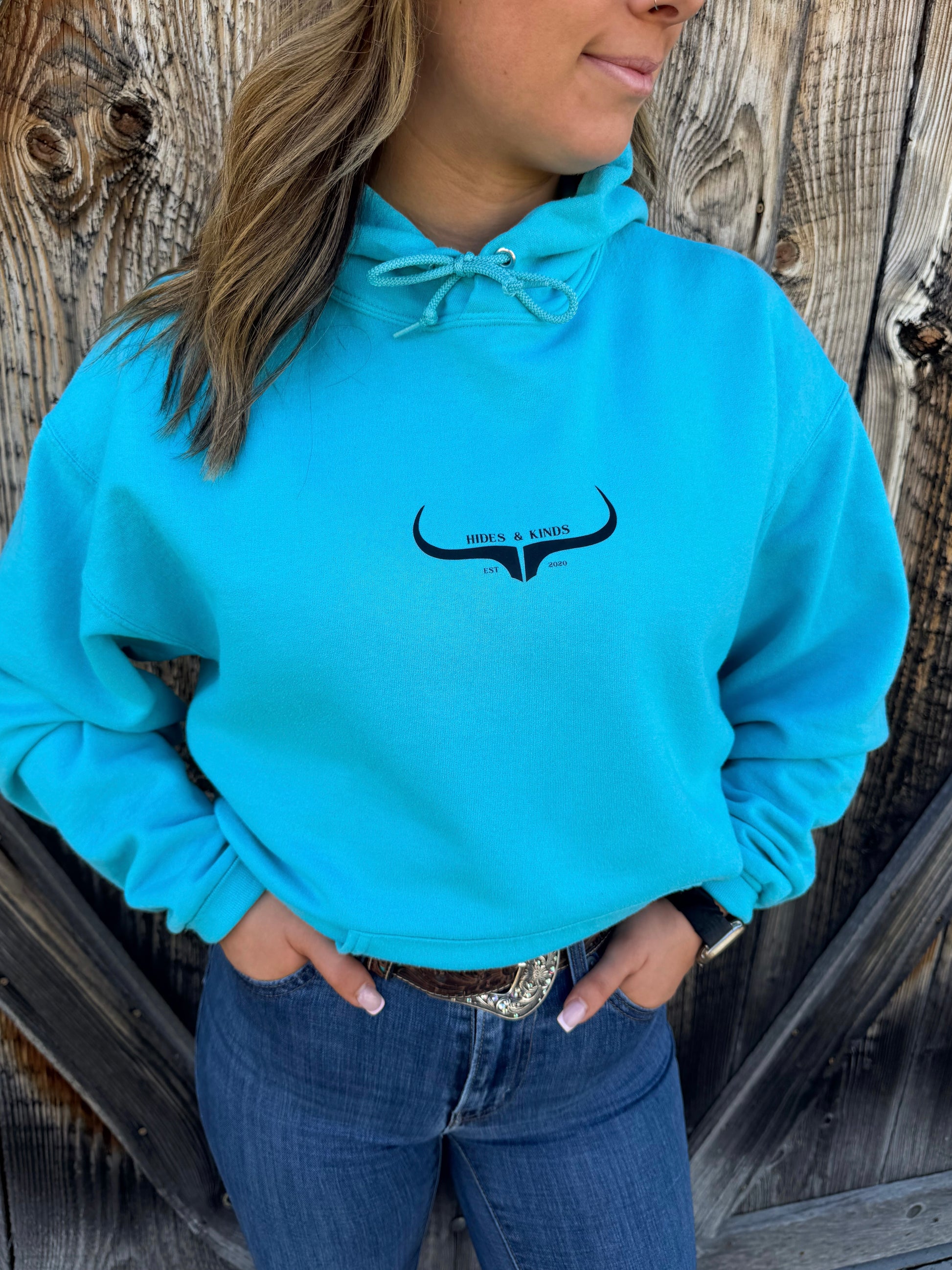 Teal western hoodie with small longhorn logo on front by Hides and Kinds