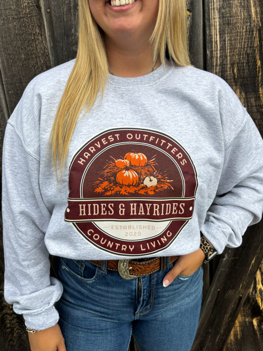 Close-up of Hides & Hayrides fall crewneck design featuring pumpkins, hay, and bold western text
