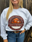 Close-up of Hides & Hayrides fall crewneck design featuring pumpkins, hay, and bold western text