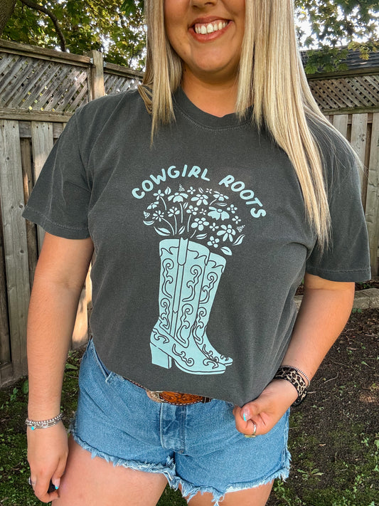 Close up of Cowgirl Roots Tee in pepper grey with light blue floral cowboy boots graphic by Hides and Kinds.