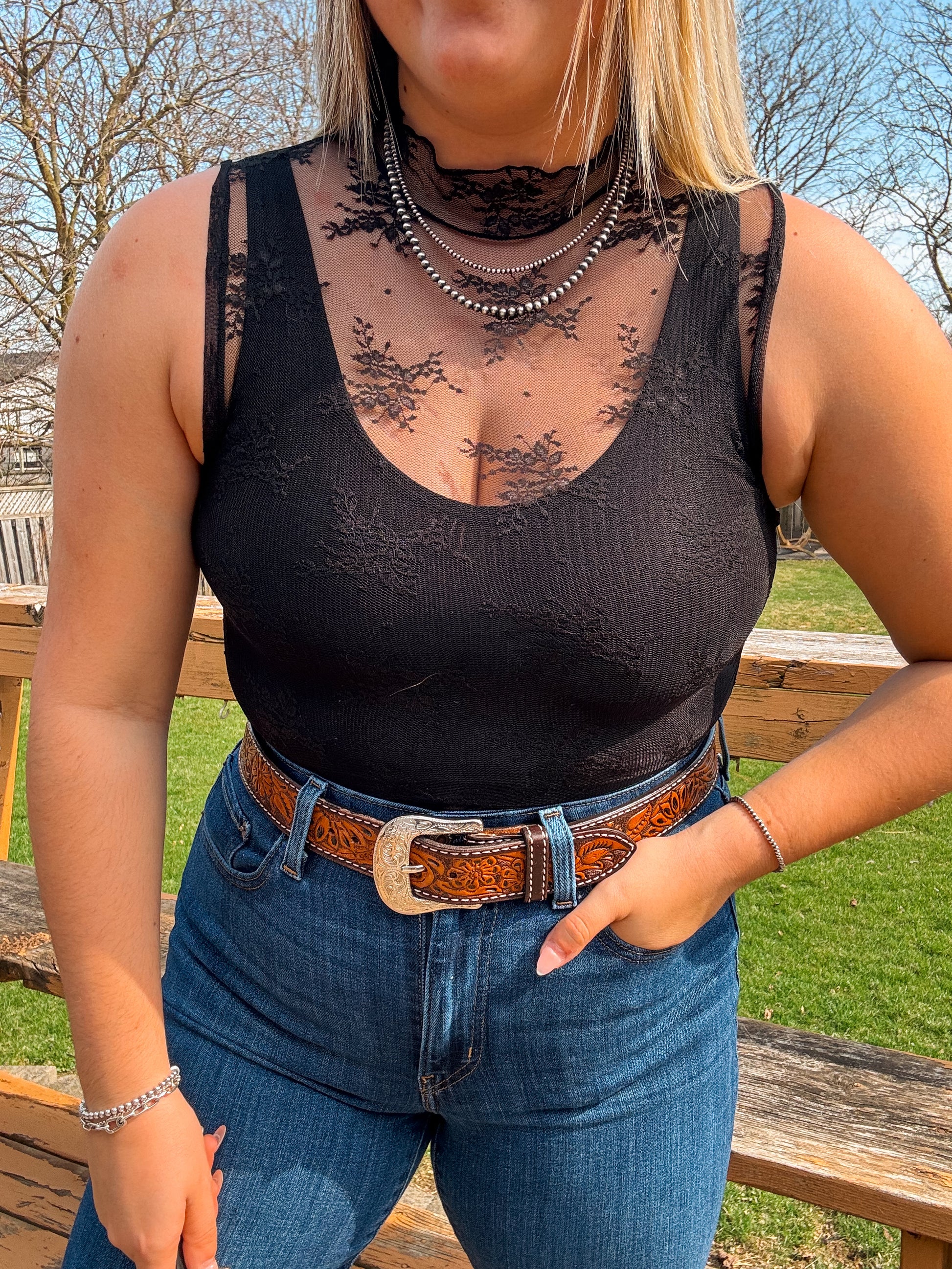 Black lace mesh tank top paired with jeans and tooled leather belt
