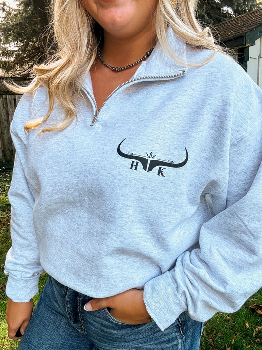 Western-inspired ash grey quarter zip sweatshirt modeled with denim jeans and belt