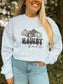 Close up of western fall crewneck with cowprint and leopard print pumpkins reading “Howdy Fall,” worn casually outdoors