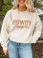 Close up of Howdy Pumpkin text design on beige crewneck with a western style rope font.