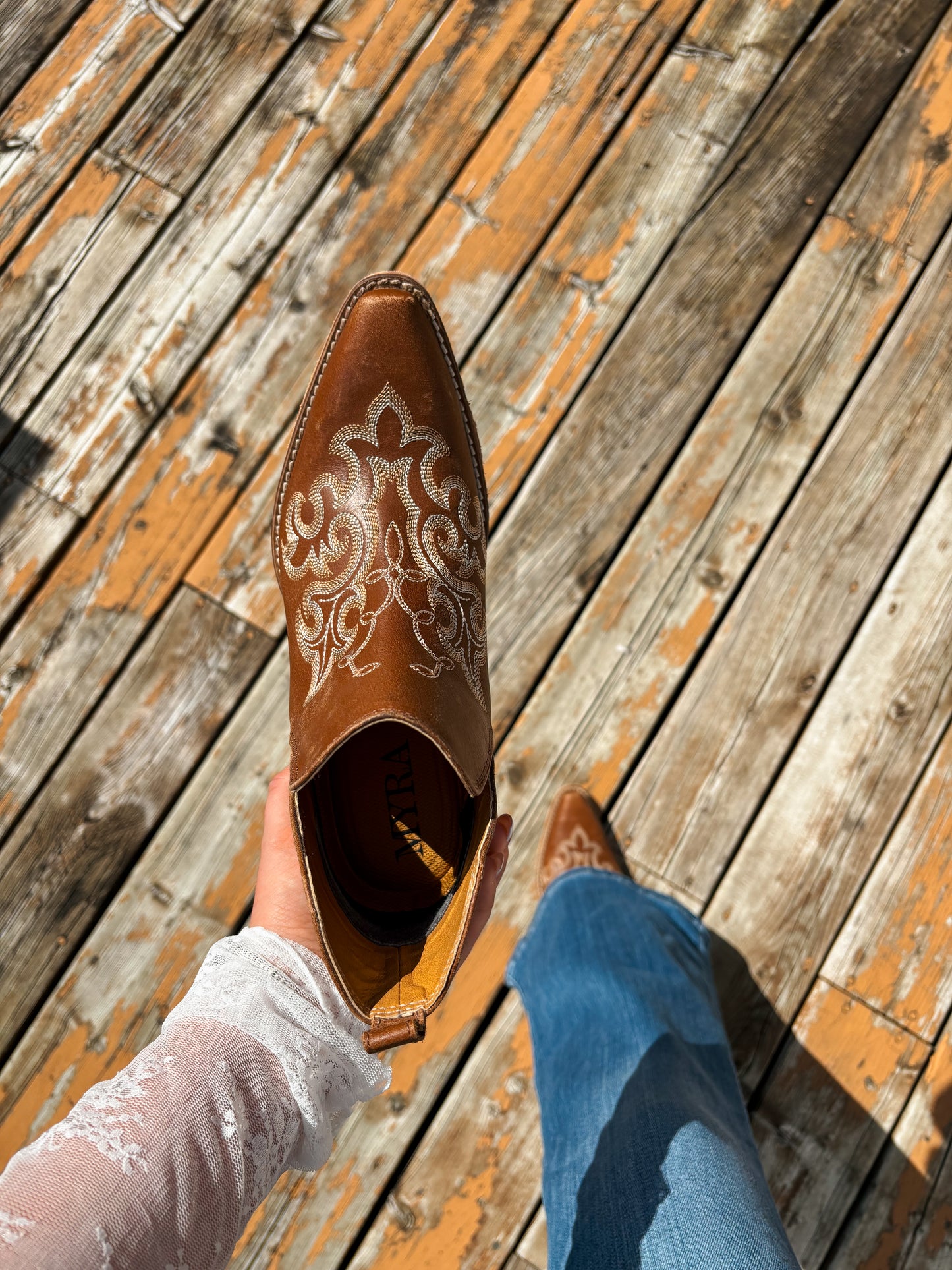 Brown Bronco Booties styled with jeans on wooden deck