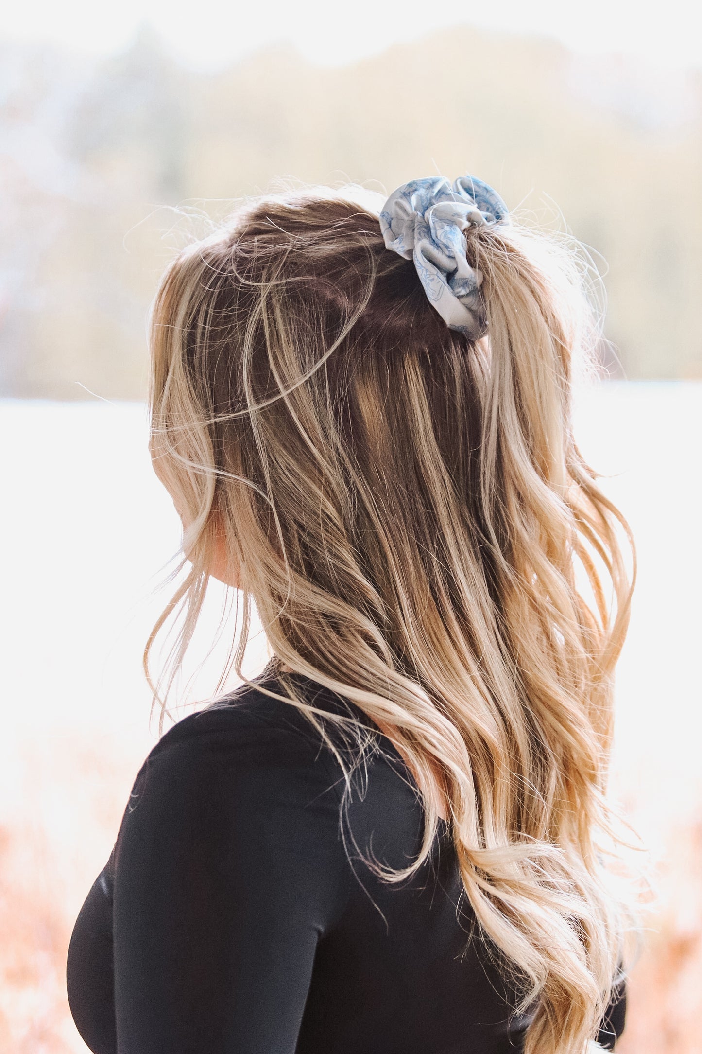 Back view of light blue cowboy scene scrunchie in long wavy blonde hair