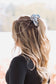 Back view of light blue cowboy scene scrunchie in long wavy blonde hair