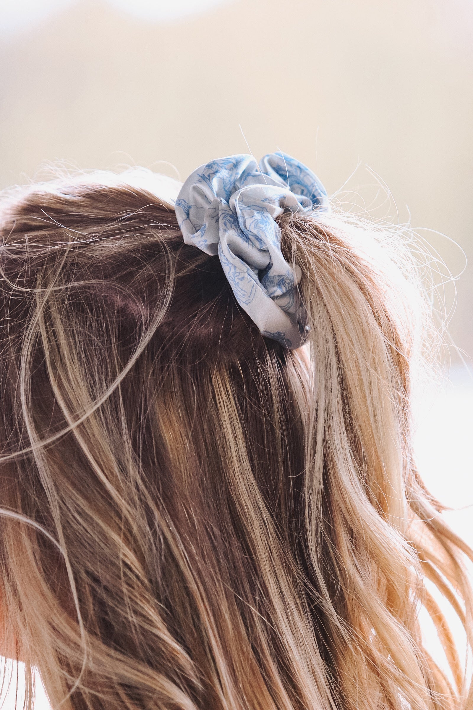 Light blue cowboy scene scrunchie styled in blonde hair, side view