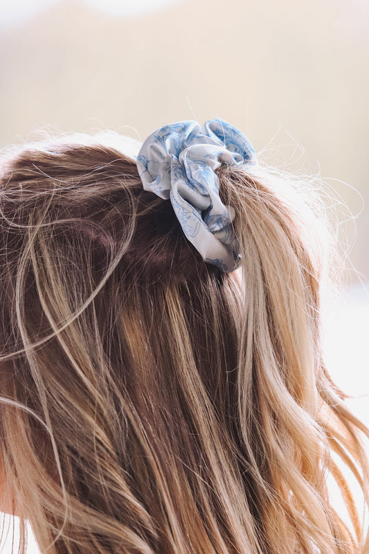 Light blue cowboy scene scrunchie styled in blonde hair, side view
