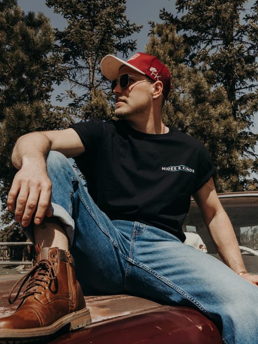 Model wearing the Hides & Kinds North Country Tee featuring the front logo and relaxed fit while outdoors.