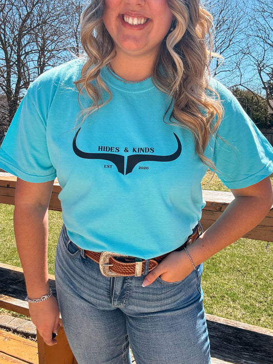 Lagoon teal western tee with front H&K branding, model smiling outdoors