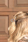 Pearl and turquoise claw clip styled in wavy blonde hair – western-inspired accessory