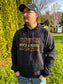 Lifestyle photo of men’s black Ranchline hoodie featuring gold Hides & Kinds western design