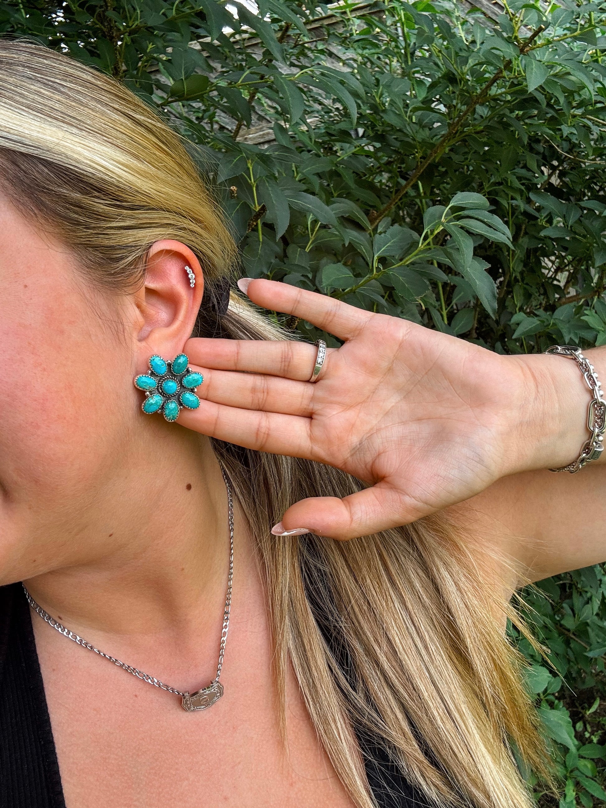 Model pulling her hair back to show H&K turquoise Rodeo Bloom earrings