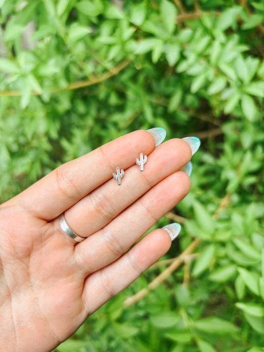 Close-up of sterling silver Saguaro Cactus stud earrings on hand – minimalist western jewelry.