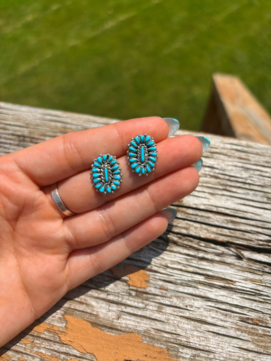 Close-up of small turquoise cluster earrings in sterling silver