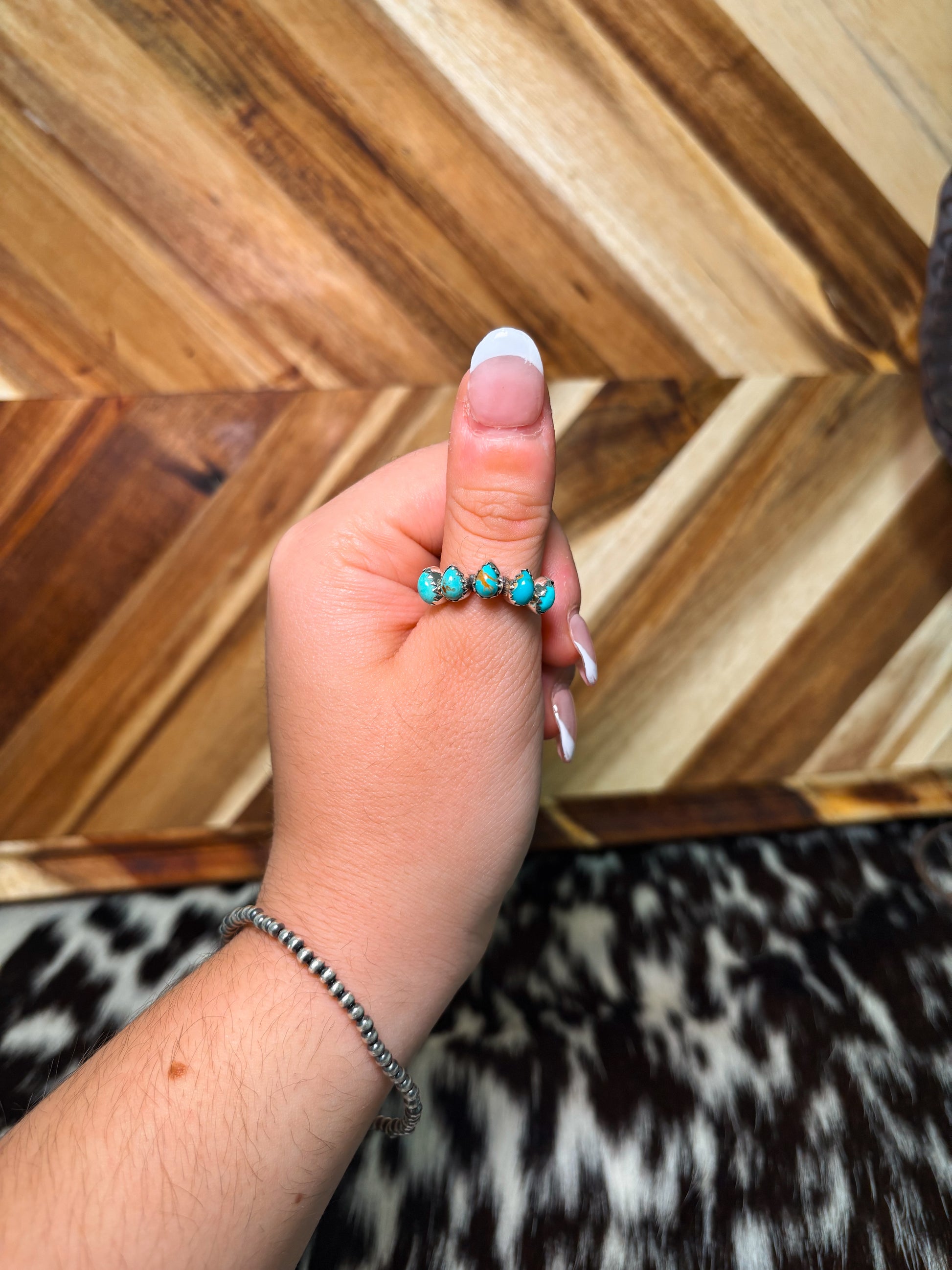 Western turquoise and sterling silver ring styled on hand