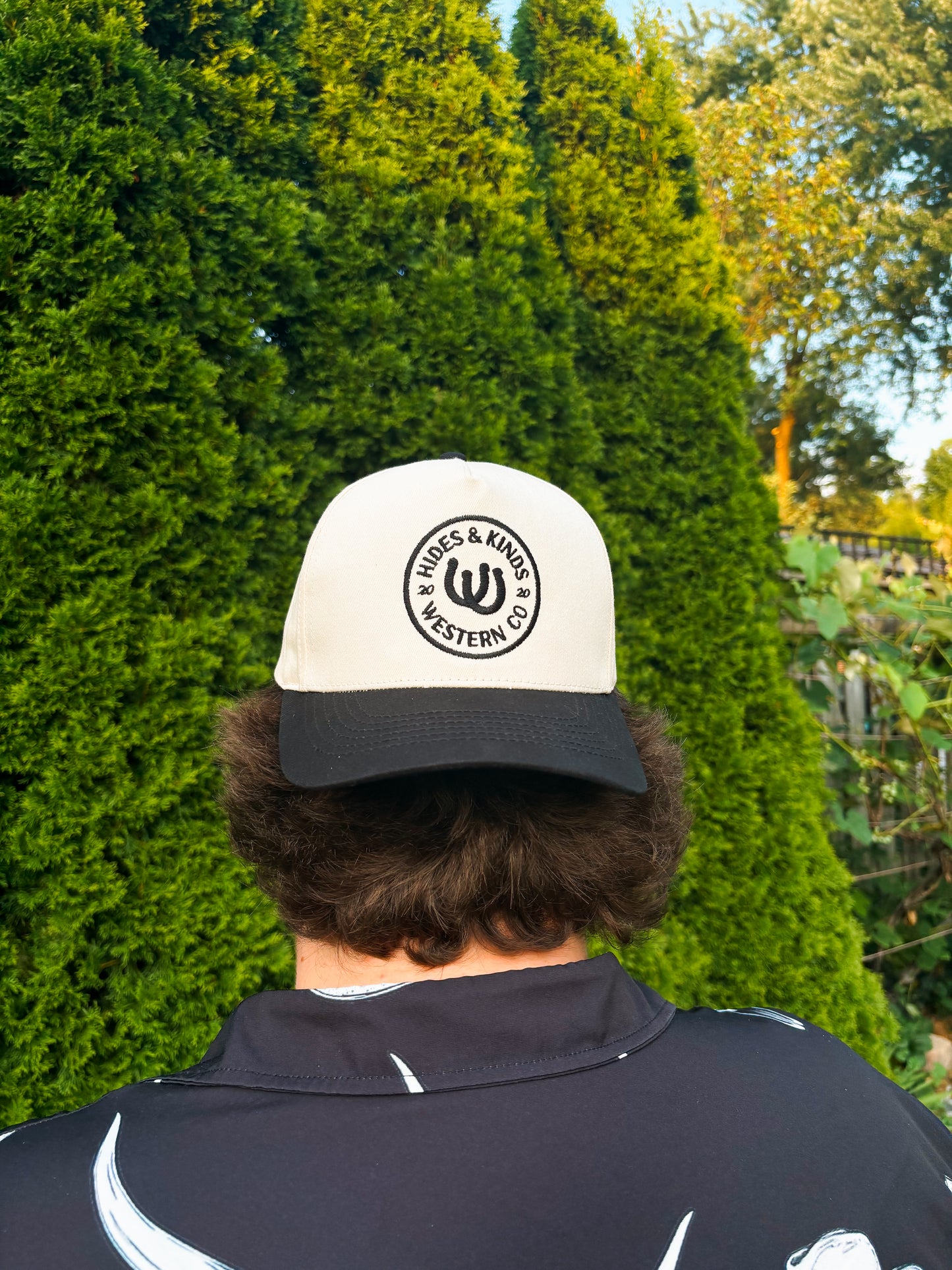 Back view of The Outrider Hat by Hides & Kinds, showing embroidered circular HK logo.